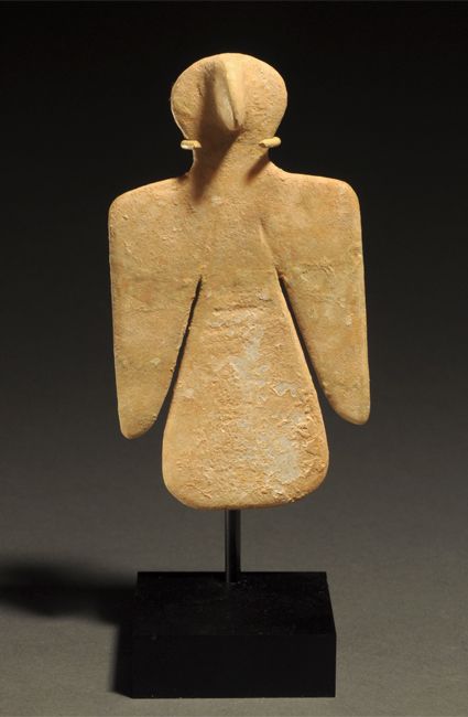 BACTRIAN MARBLE STYLIZED BIRD-FORM IDOL Wings depicted as if open on either side of the body; the head introduced as humanoid, the beak becoming a nose. Late 3rd-early 2nd Millennium BC