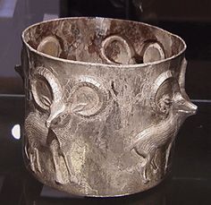 Bactrian silver cylindrical cup, circa late 3rd to Early 2nd Millennium B.C. ,Bactrian silver cylindrical cup, circa late 3rd to Early 2nd Millennium B.C., shown above. The hammered vessel, which stands on a low foot, has four goats in relief in profile with projecting heads framed by great curving horns.