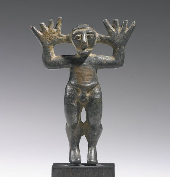 A BRONZE FIGURE OF A MAN, SYRO-PHOENICIAN(?), CIRCA MID 1ST MILLENNIUM B.C. standing in a lively pose with his big raised hands splayed wide, the face with short projecting beard, large beaked nose, and bulging eyes with prominent brows. Height 2 5/16 in. 5.8 cm.