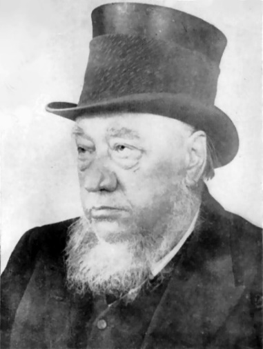 Paul Kruger as an old man with a grey beard wearing a black top hat as well as pirate style earings